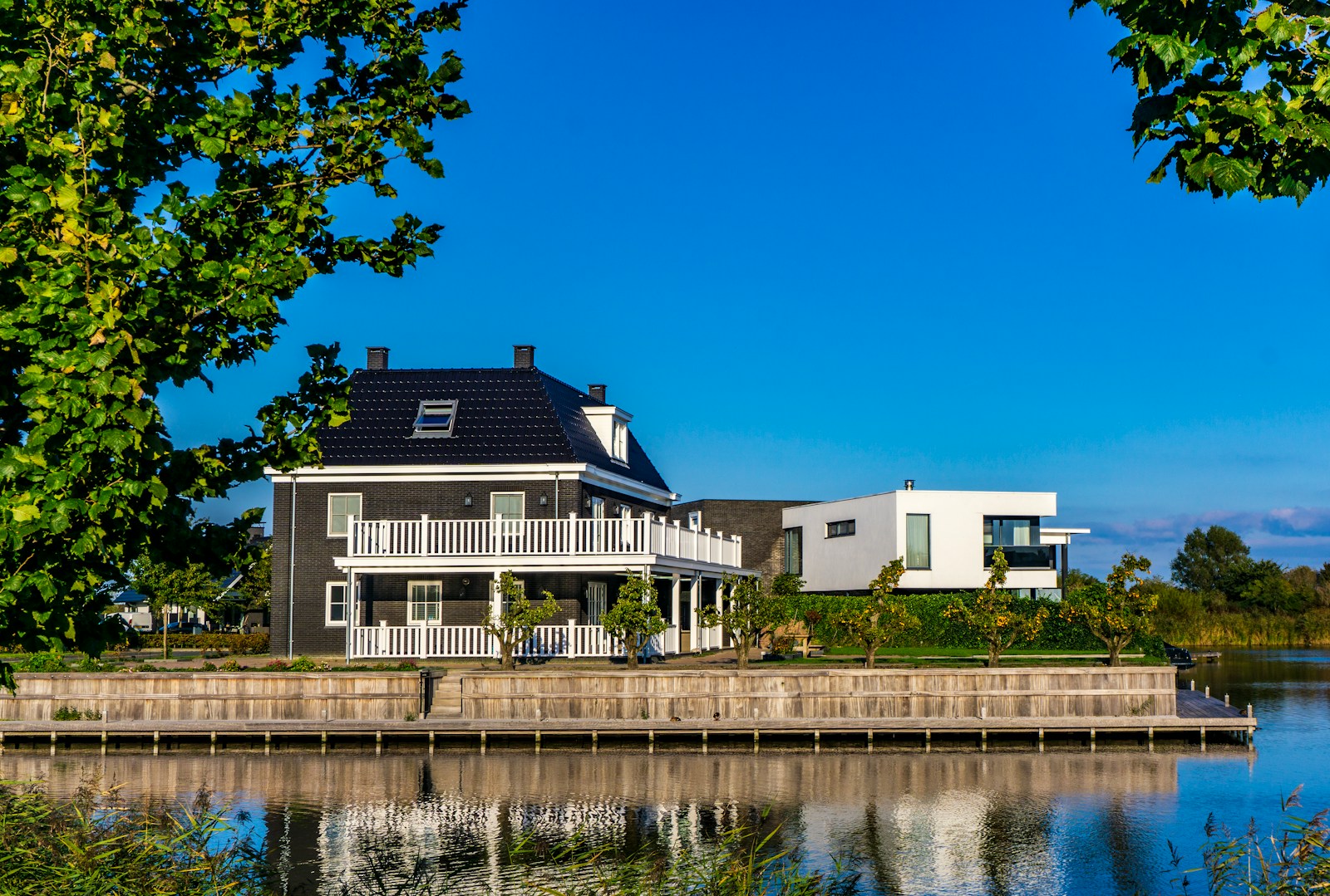 white and black house beside body of water during daytime
